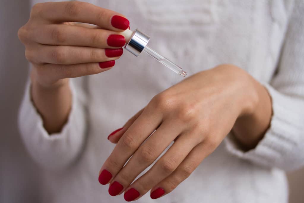 Ingredients To Avoid in Skin Care 4 female hands used serum on a white background SBI 310340393 1